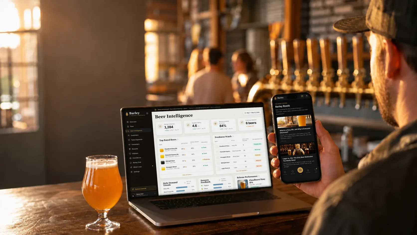 A guest at a taproom bar reads Barley Reads on his phone, with the Brewlytics Beer Intelligence dashboard open on the laptop beside a tulip of hazy IPA: ratings collected, recommendation accuracy, the freshness watchlist and the top rated beers.