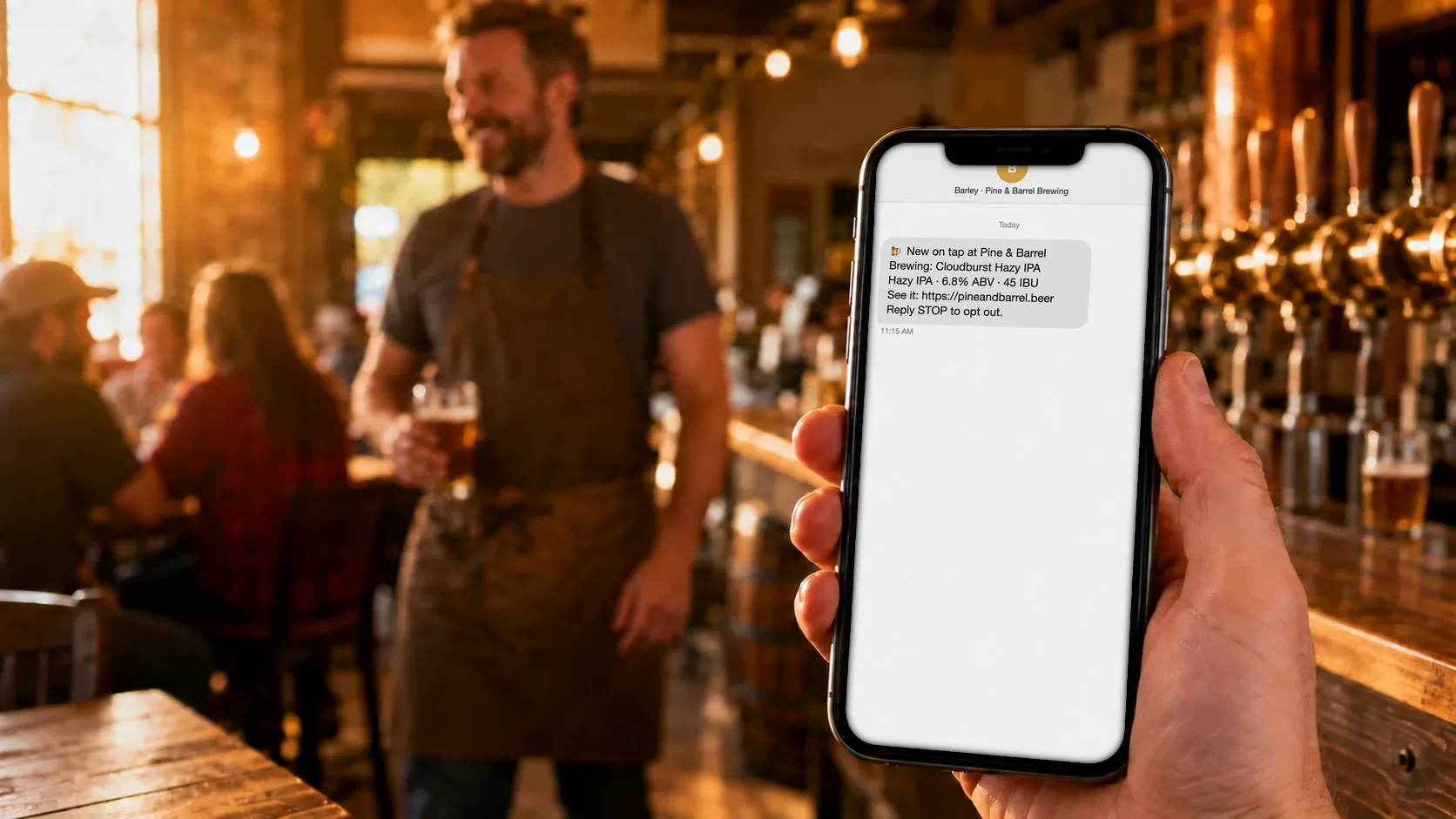 A hand holds up a phone with a Release Radar text from Barley, new on tap at Pine & Barrel Brewing: Cloudburst Hazy IPA, 6.8% ABV, 45 IBU, while a bartender smiles in the taproom behind it.